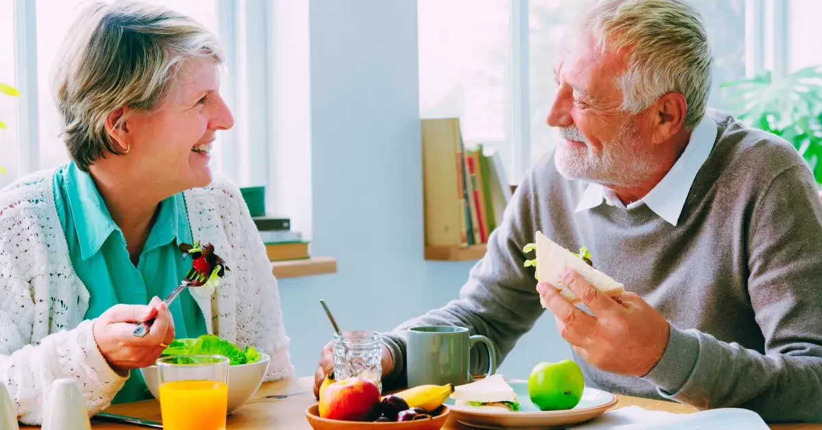 duas-pessoas-idosas-sentados-a-mesa-ingerindo-alimentos-saudaveis