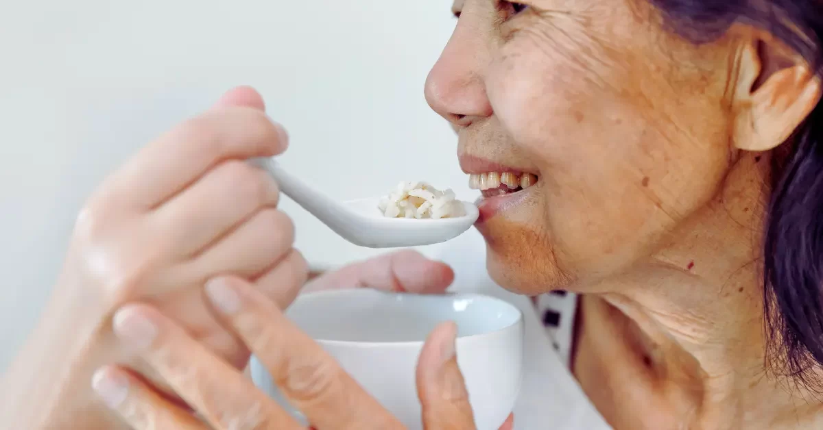 cuidador-de-idosos-alimentando-seu-paciente